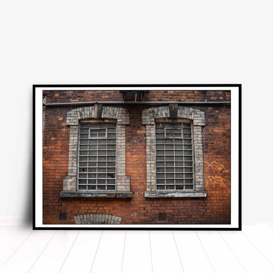 This is a photographic print taken in Manchester of a set of old industrial windows.