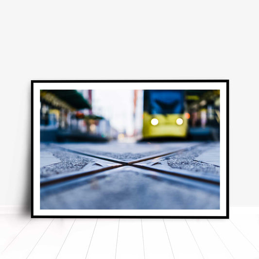 Photographic print of Manchester tram lines crossing with a soft-focus effect on the tram in the background