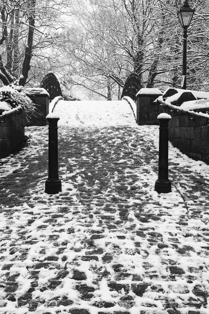 Richard Abram Photography - The photographic scenic print was taken on the Worsley canal in Greater Manchester. Taken on a wintery morning day. The image shows a snow scene with the cast-iron footbridge covered in winter snowy footprints.