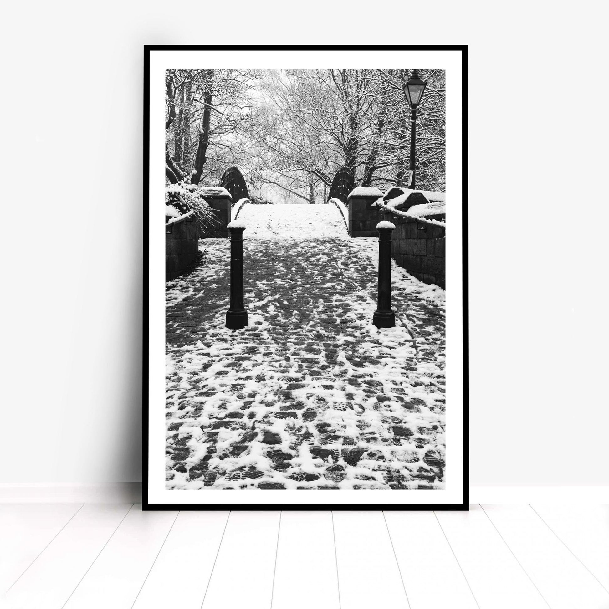 Richard Abram Photography - The photographic scenic print was taken on the Worsley canal in Greater Manchester. Taken on a wintery morning day. The image shows a snow scene with the cast-iron footbridge covered in winter snowy footprints.