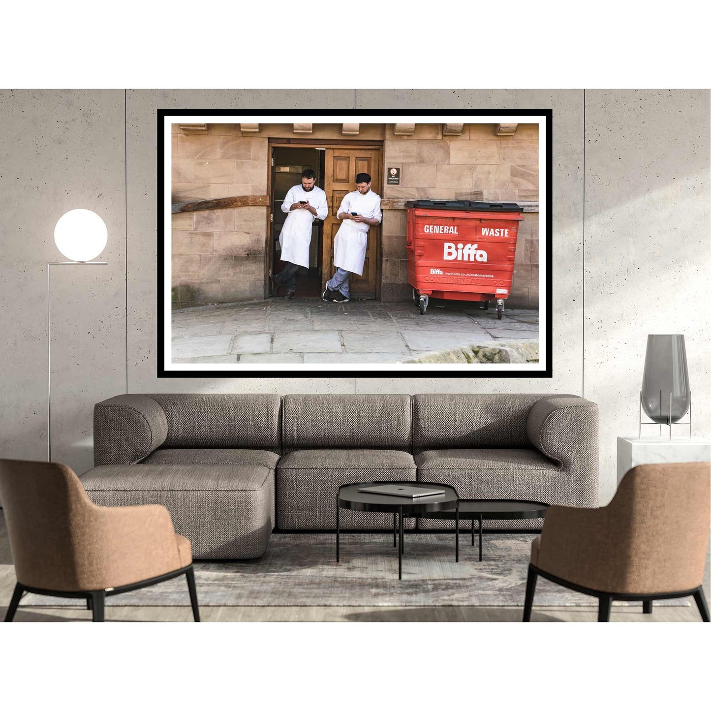 A photographic print was taken in Manchester, England showing street photography of two men on a break who stood by a wall.