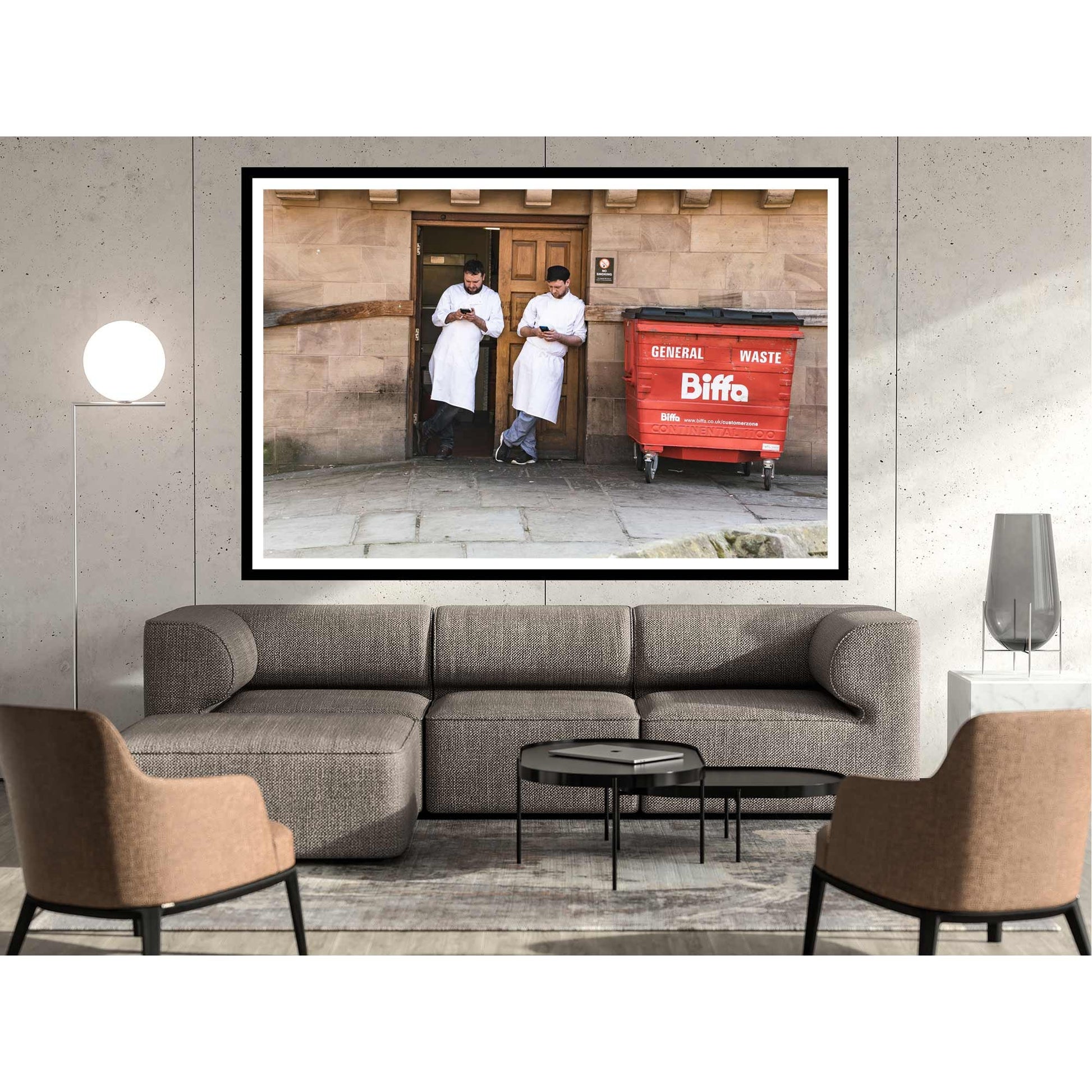 A photographic print was taken in Manchester, England showing street photography of two men on a break who stood by a wall.