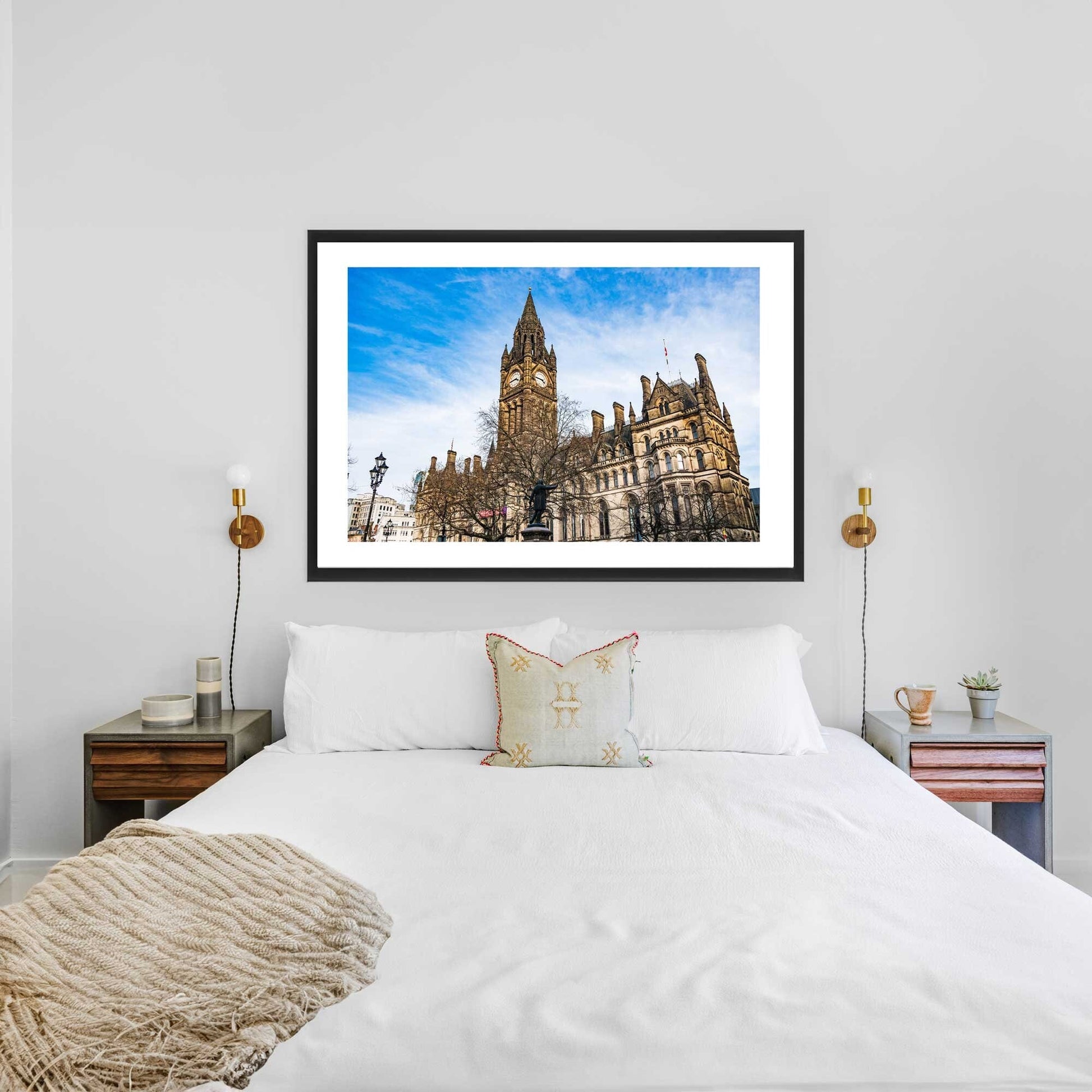 This is a photographic print of the Manchester Town Hall. The photo shows the front of the building with the clock tower. You can see a blue sky with some clouds.